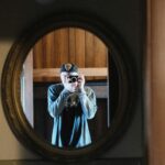 Man taking photo of bathroom mirror