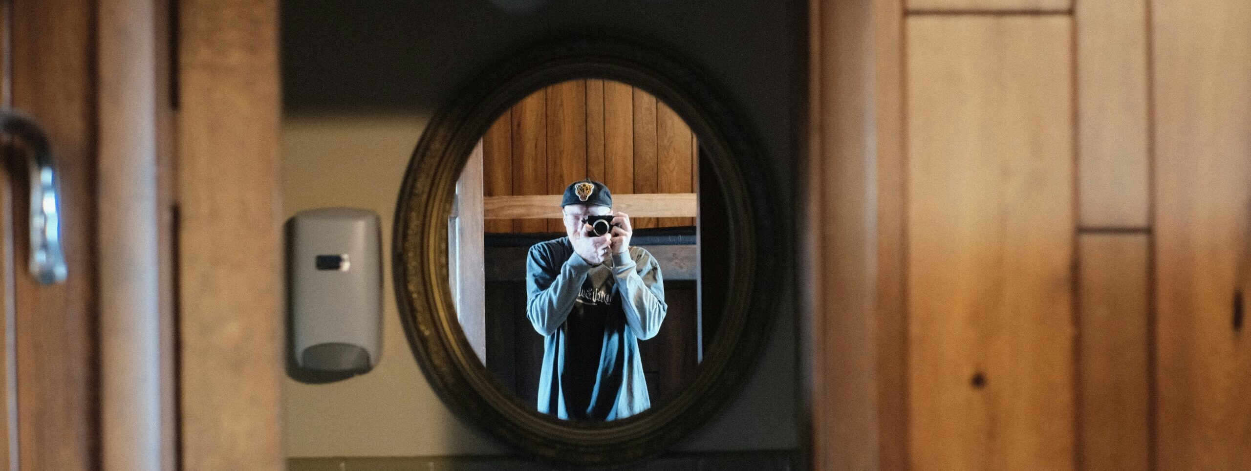 Man taking photo of bathroom mirror